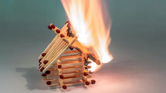 A burning house made of matchsticks